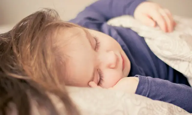 Dziecko śpi spokojnie, choć czasem **moczenie nocne na tle nerwowym** może zakłócać sen.