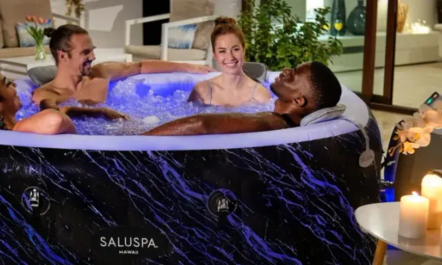 Quatre amis profitent d'un moment de détente dans un spa gonflable, illuminé de bleu. L'entretien de ce spa gonflable est simple pour des moments de pur bonheur.