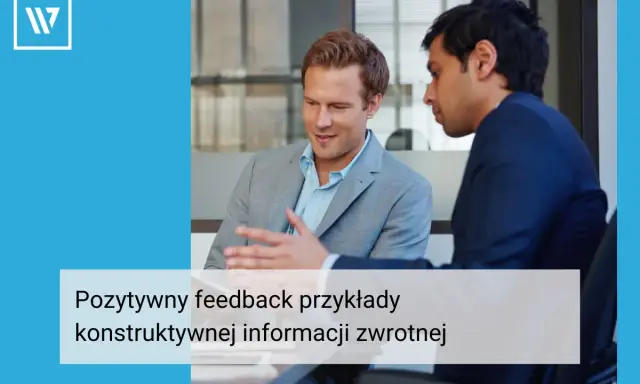 Dwóch mężczyzn w garniturach rozmawia przy biurku. Jeden z nich gestykuluje, omawiając pozytywny feedback dla pracownika, przykłady konstruktywnej informacji zwrotnej.