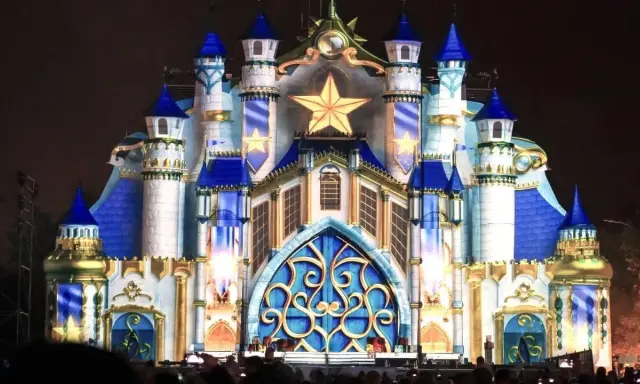 Castillo iluminado con estrellas doradas y detalles azules, evocando la magia de las **parques mágicas navidades**.