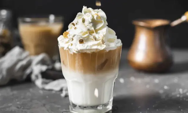 Un délicieux café liégeois, couronné de chantilly et de quelques éclats croquants, prêt à être dégusté.