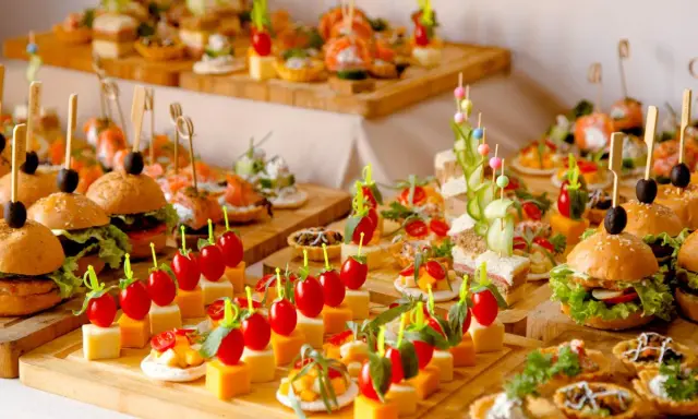 Deliciosos entrantes para boda: mini hamburguesas, canapés de salmón, brochetas de tomate y queso, y tartas saladas.