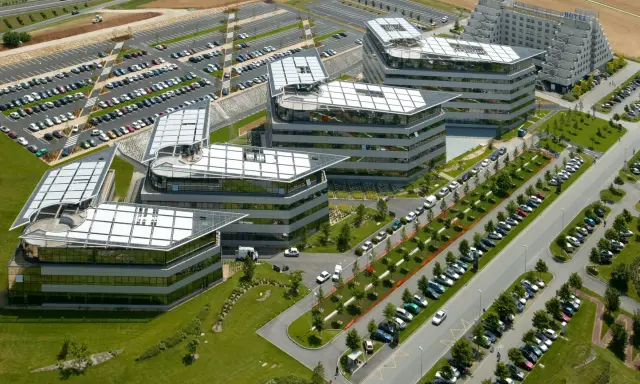 Vue aérienne de bâtiments modernes avec des parkings. On imagine un déjeuner d'affaires au restaurant La Javette.