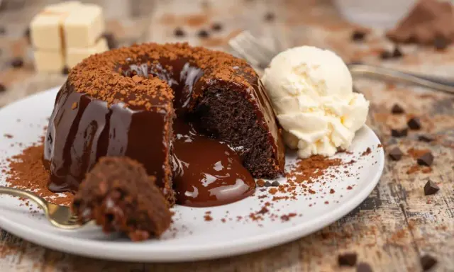 Gâteau au chocolat coulant, illustrant la différence entre moelleux et fondant. Servi avec une boule de glace à la vanille.