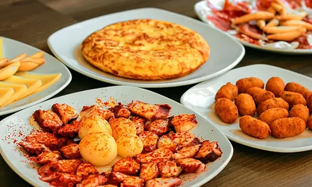 Pulpo a la gallega, tortilla española, croquetas y queso. Un festín digno del sobrino de botín, ¡menú para disfrutar!