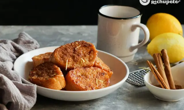 Torrijas de pan doradas y crujientes, espolvoreadas con ralladura de limón. Un clásico de las recetas de torrijas de pan, perfecto para disfrutar.