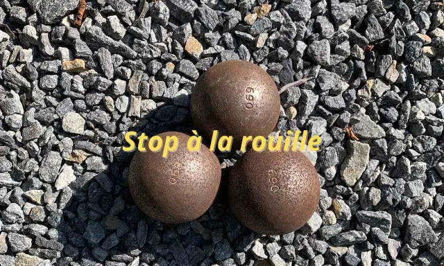 Trois boules de pétanque rouillées sur des graviers. Apprenez comment nettoyer des boules de pétanque pour qu'elles retrouvent leur éclat.