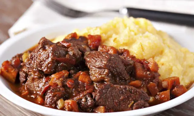 Un plat de daube de sanglier sans marinade, mijoté avec des légumes, servi avec une purée de maïs crémeuse. Un délice !