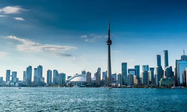 Widok na Toronto z wieżą CN i nowoczesnymi wieżowcami. Marzenie o locie do Warszawy w tle.