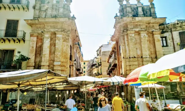 Mercato vivace a Palermo, tra bancarelle colorate e antiche architetture. Un'ottima idea per le cose da fare a Palermo, tra sapori e storia.