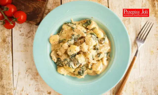 Pyszne gnocchi z kurczakiem i szpinakiem w kremowym sosie, posypane parmezanem. Idealne danie na obiad.