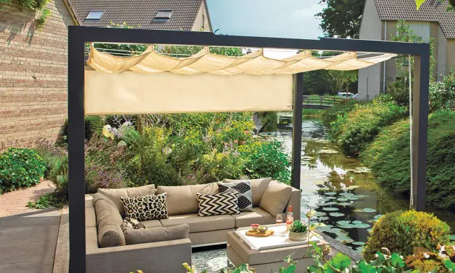 Nowoczesna pergola z wysuwanym daszkiem to świetny sposób, jak osłonić taras od wiatru i słońca. Wygodny narożnik i stolik zachęcają do relaksu.