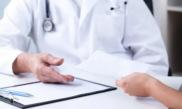 Lekarz przekazuje pacjentowi skierowanie. Szukasz, gdzie najszybciej rehabilitacja NFZ CzęSTOCHOWA?