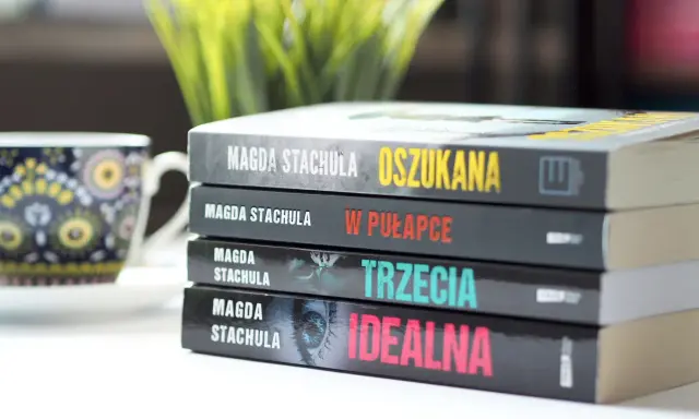 Kolejność czytania książek Magdy Stachuli: "Oszukana", "W pułapce", "Trzecia", "Idealna". Obok filiżanka.