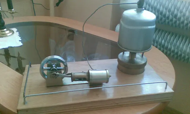Miniaturowy silnik parowy z prądnicą, gotowy do pracy.