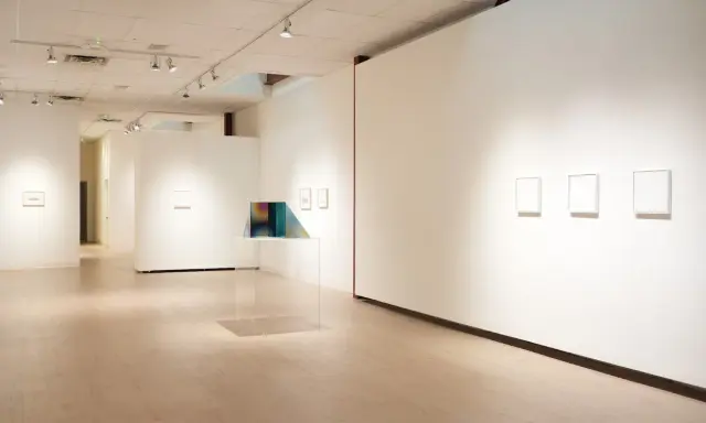 Inside the Richard Levy Gallery, minimalist artworks are displayed on white walls with polished wooden floors.