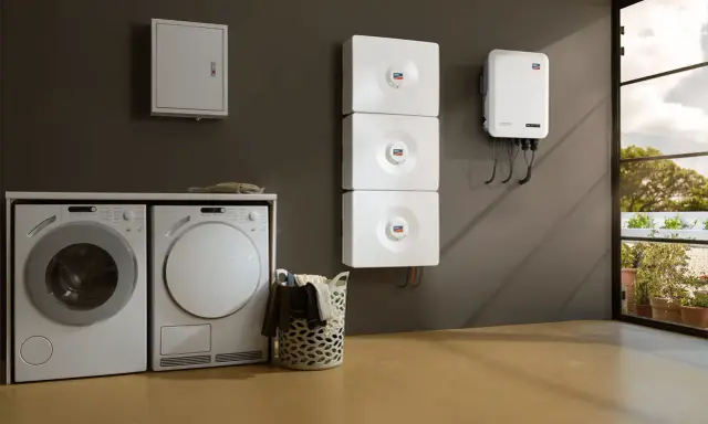 Lave-linge et sèche-linge à côté d'un système de stockage d'énergie solaire, prêt pour un séchage écologique.