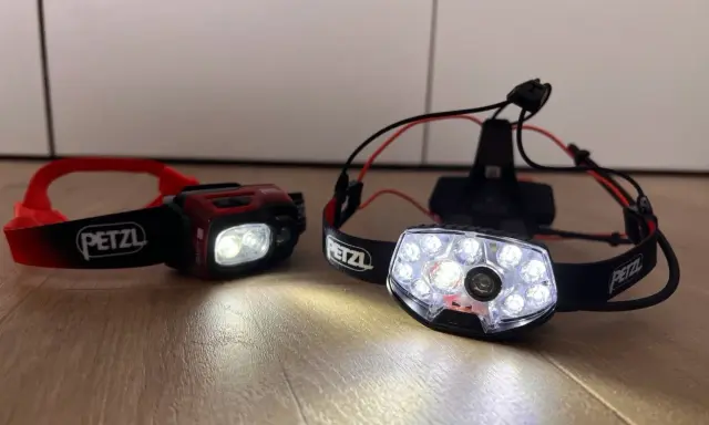 Dwie czołówki Petzl, gotowe na nocne bieganie. Jedna czerwona, druga z wieloma diodami.