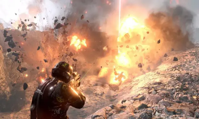 Żołnierz w zbroi walczy w ogniu eksplozji, odłamki skał latają wokół. To scena z gry Helldivers 2.