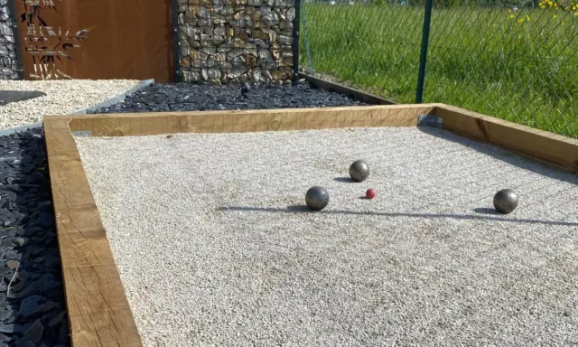 Terrain de pétanque avec boules et cochonnet sur du gravier fin. Le choix du quel sable pour terrain de pétanque est crucial pour un jeu parfait.