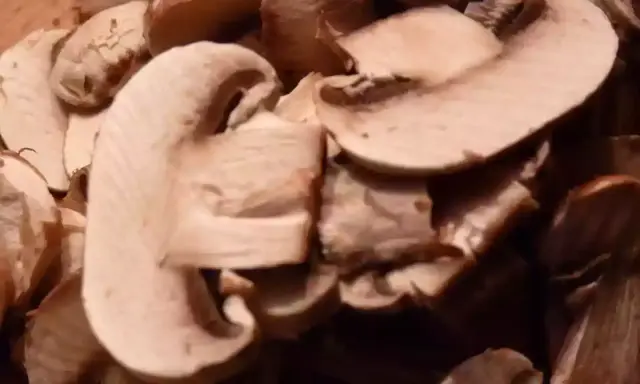 Champignons coupés en lamelles, prêts pour une recette de champignons à la grecque.