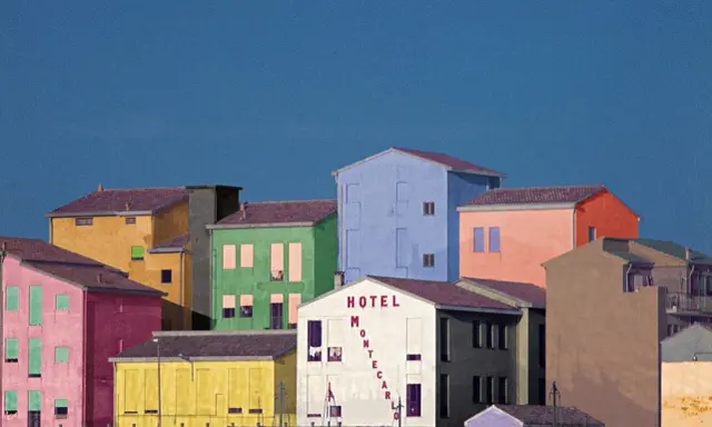 Case colorate e un cielo blu intenso, un paesaggio che ricorda le opere di Franco Fontana.