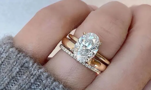Un solitario anello con diamante ovale, simbolo di un amore eterno e prezioso, adorna un dito.