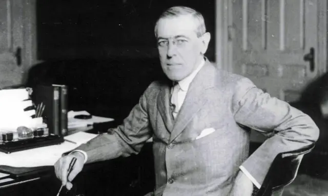 Woodrow Wilson, der den 14-Punkte-Plan zur Friedenssicherung nach dem Ersten Weltkrieg entwickelte, sitzt an seinem Schreibtisch.