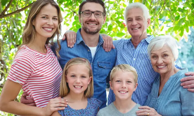 Familia sonriente, de abuelos a nietos, mostrando el factor hereditario en sus rasgos.