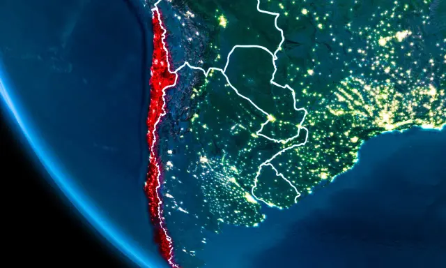 Widok z kosmosu nocą, gdzie leży Chile, podkreślone na czerwono, wzdłuż wybrzeża Pacyfiku.