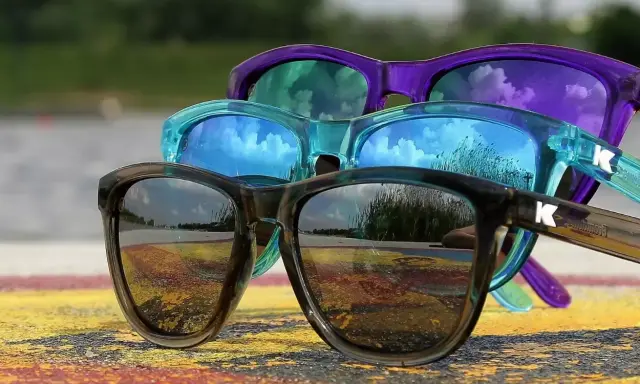 Trzy kolorowe okulary przeciwsłoneczne, idealne do samochodu, odbijają niebo i otoczenie.