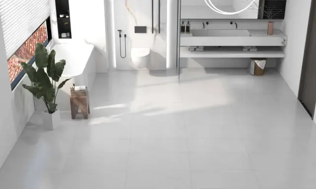 Salle de bain moderne avec baignoire, douche, lavabo et toilettes, le tout sur un sol en dalle pvc ou carrelage blanc.