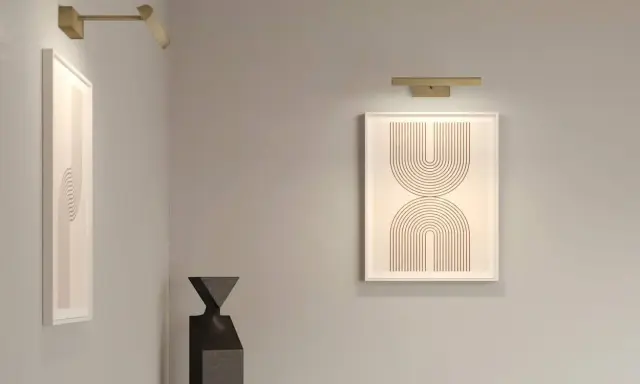 Nowoczesna lampa galeryjka podkreśla abstrakcyjne obrazy i rzeźbę w minimalistycznym wnętrzu.