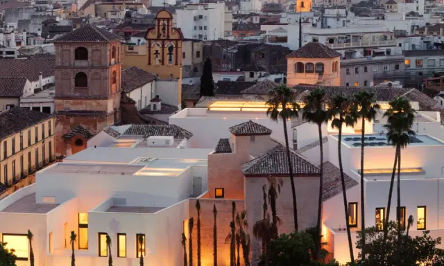Das Picasso Museum in Spanien, Malaga, mit seinen modernen weißen Gebäuden und Palmen im Abendlicht.