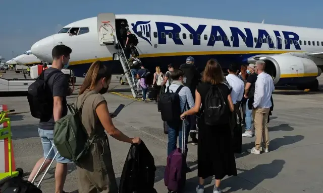 Pasażerowie wchodzą po schodkach do samolotu Ryanair.