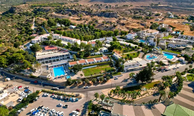 Widok z lotu ptaka na hotel Ellia Rodos z basenami, zjeżdżalniami i parkingiem pełnym samochodów.