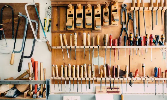 Un taller organizado con sierras, cepillos, destornilladores y limas colgados en la pared. Un ejemplo de **ordenar herramientas casero** para tener todo a mano.