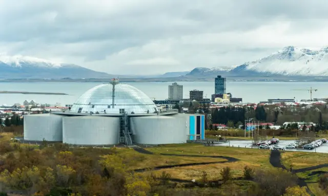 Große Kuppel und Tanks, Teil der island stromerzeugung, mit schneebedeckten Bergen im Hintergrund.
