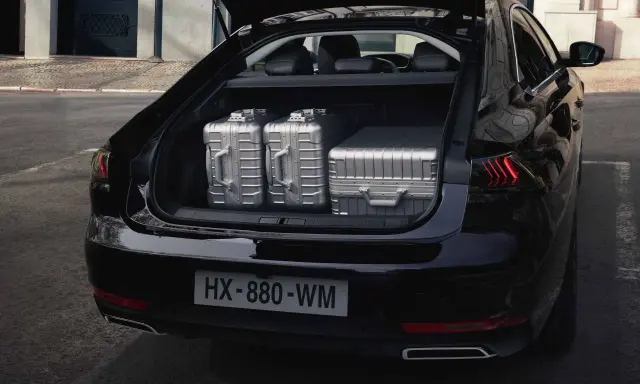 Maletero del Peugeot 508 SW listo para un viaje, con tres maletas plateadas de gran capacidad.