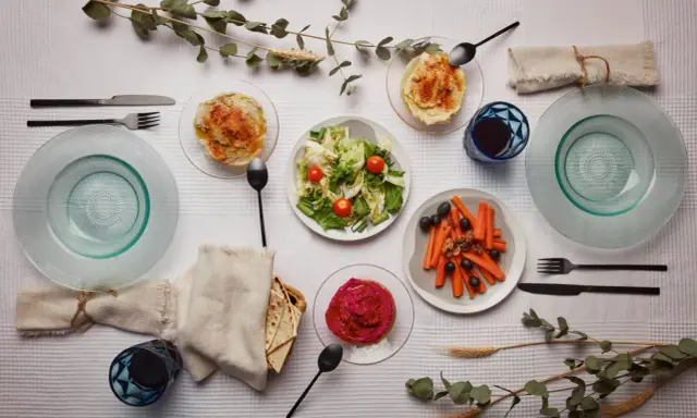 Un repas végétarien servi à l'assiette : houmous, salade, carottes et betterave. Une belle définition du service à l'assiette.