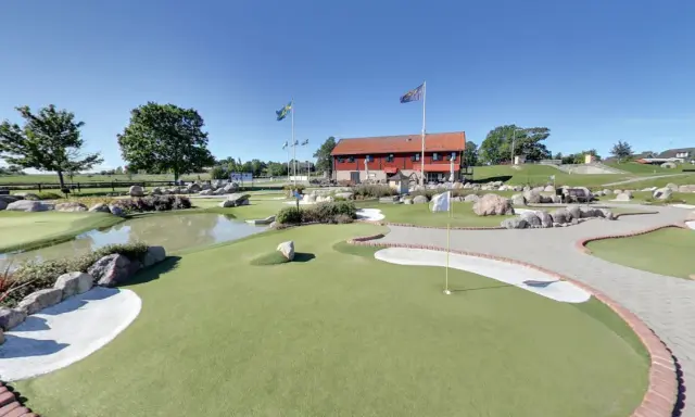 En solig dag på slussen minigolf i Sverige. Grönskande banor, vattenhål och stenar skapar en utmanande och rolig miljö.