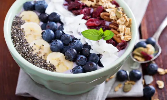 Miseczka pełna super foods: jagody, banany, nasiona chia, płatki kokosa, żurawina i granola. Idealne śniadanie.