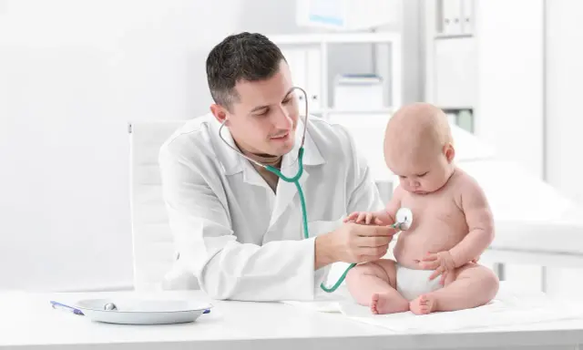 Pediatra bada prawidłową klatkę piersiową u dziecka stetoskopem.