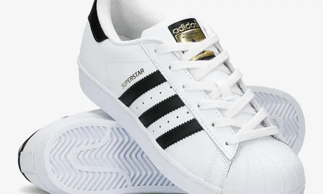 Białe adidas Superstar z czarnymi paskami i złotym logo. Poznaj, czym się różnią modele.