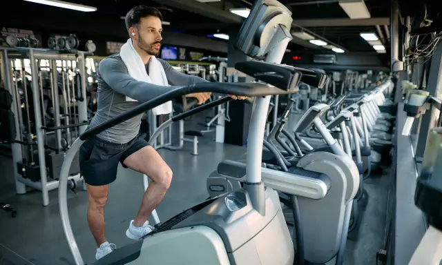 Mann macht ein Stairmaster Workout im Fitnessstudio.