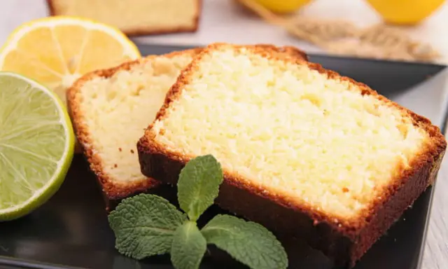 Tranches de cake au citron facile, garnies de menthe fraîche, avec des citrons et citrons verts en arrière-plan.
