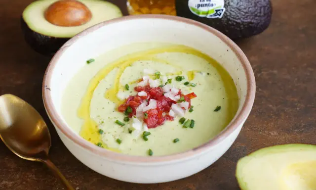 Un cremoso gazpacho de aguacate, coronado con tomate picado, cebolla y cebollino. Un chorrito de aceite de oliva realza su frescura.