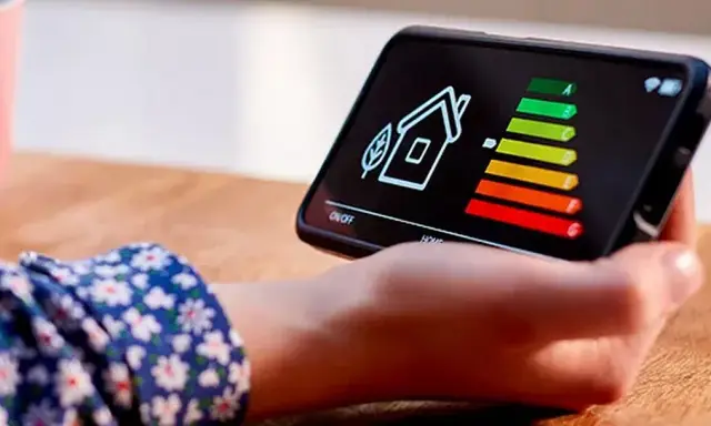 Écran de smartphone affichant une maison et un barème d'efficacité énergétique. La question "une clim consomme plus en chaud ou froid" est implicite.