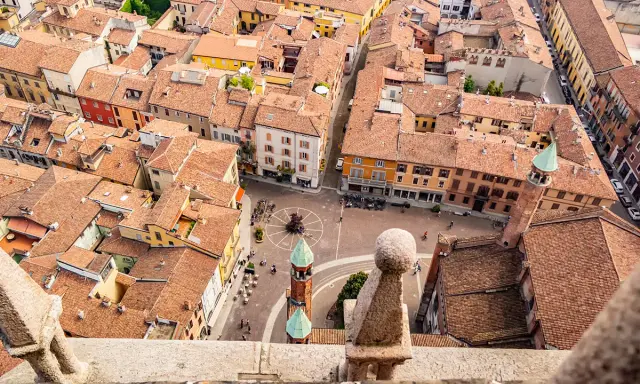 Vista aerea di Cremona: tetti rossi, piazze animate e torri. Un assaggio di cosa vedere a Cremona in un giorno.