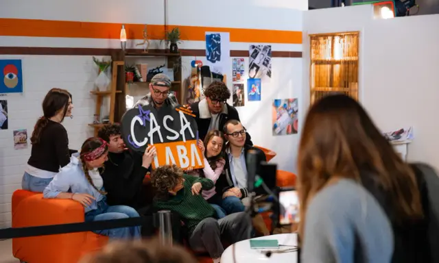 A group of young people pose for a photo, holding a sign that says "CASA LABA".